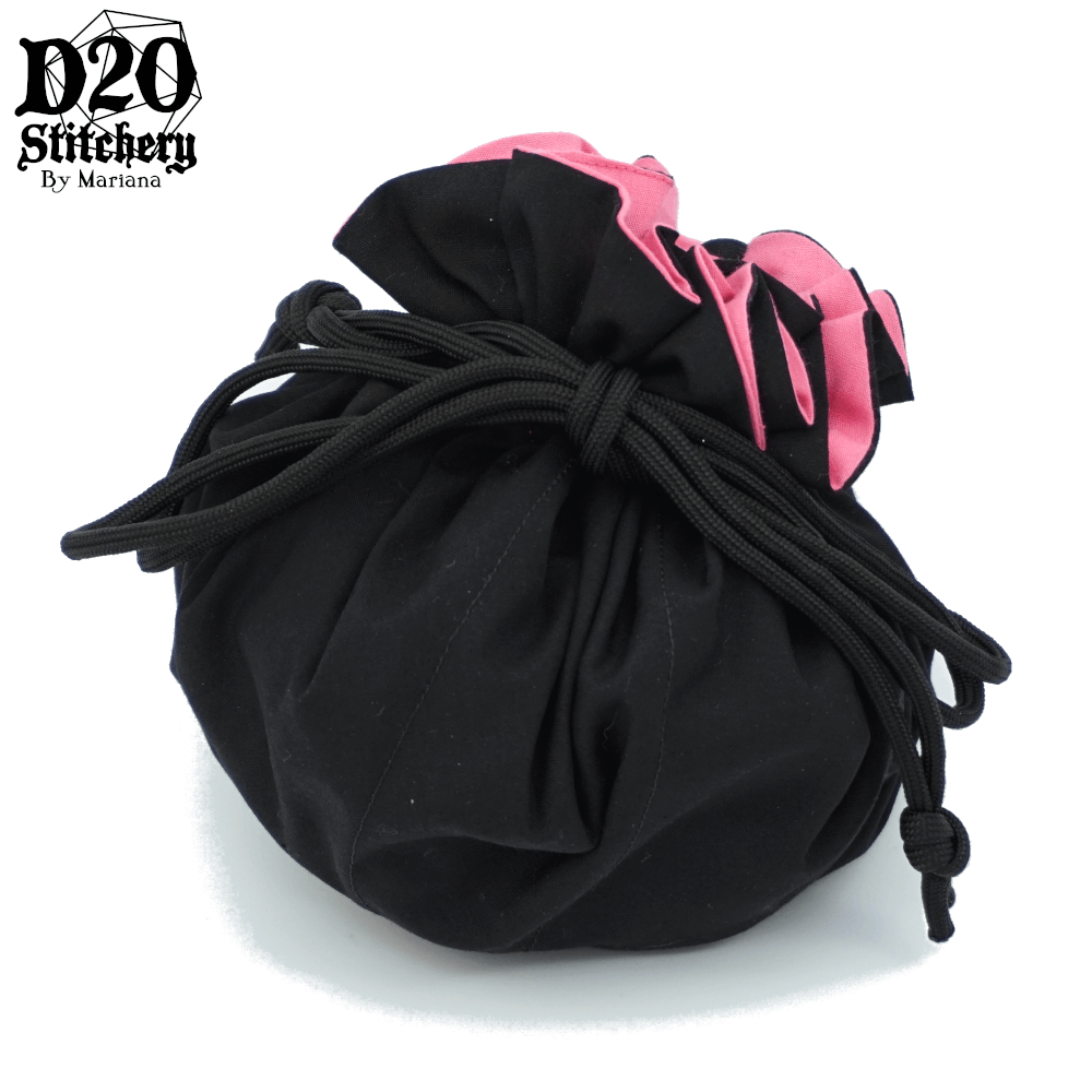 Epic dice bag with medium pink lining and black exterior fabric tied with black paracord.