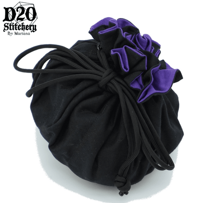 Epic dice bag with medium purple lining and black exterior fabric tied with black paracord.