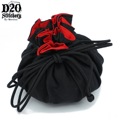 Epic dice bag with bright red lining and black exterior fabric tied with black paracord.