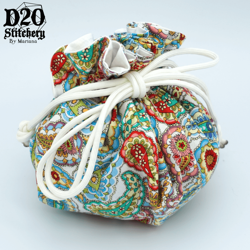 Epic dice bag with various colorful paisleys on a white background tied with white paracord.